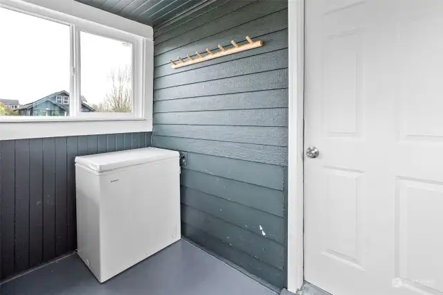 Mud room off the dining nook with chest freezer. This room leads to the backyard.