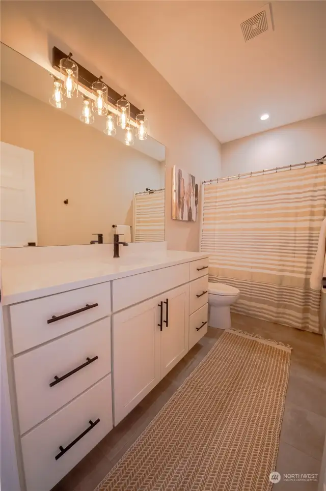 The guest bath has a large vanity with plenty of storage.