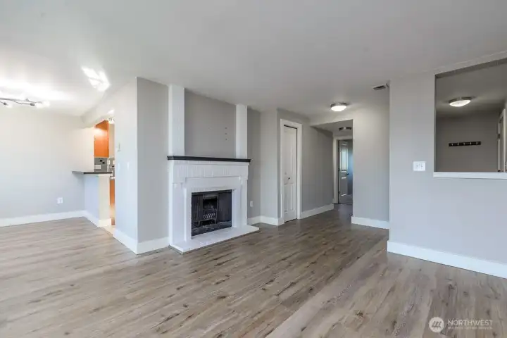 Living room view of entry and hall to laundry and bedrooms.