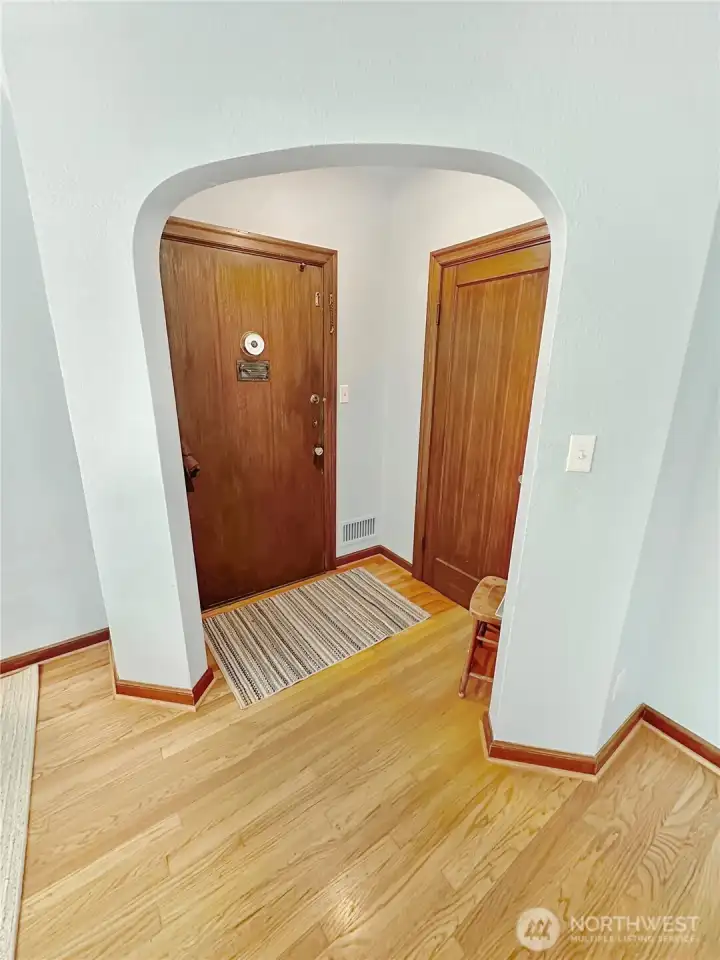 Entry alcove with coat closet and gracious, timeless arched doorway.