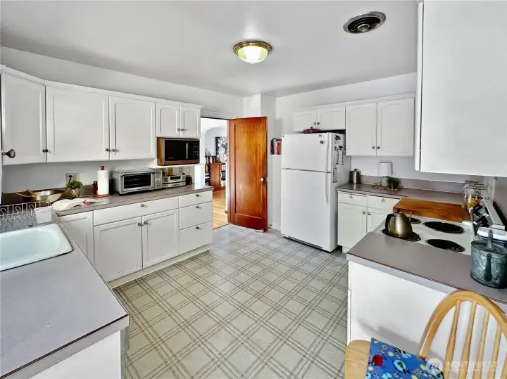 Ample kitchen with loads of cabinets, eating nook and access to the basement, primary bedroom and rear deck and yard.
