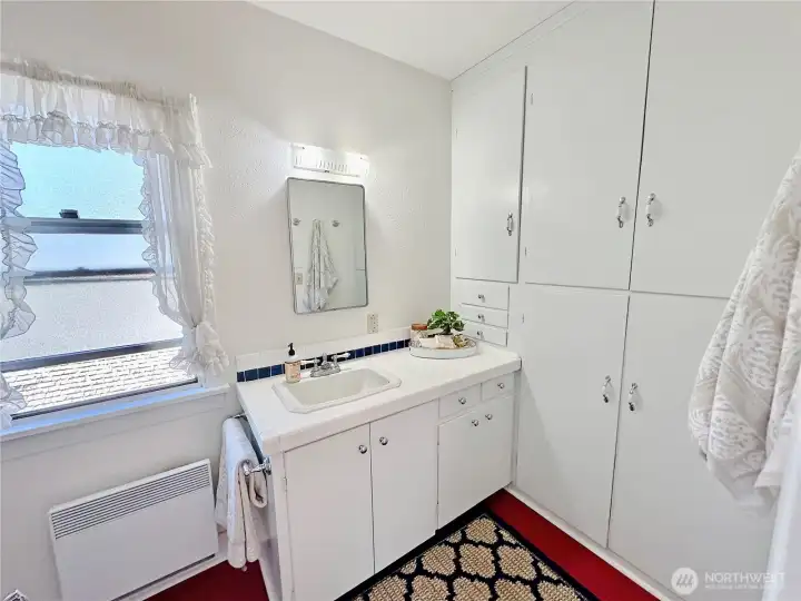 Primary 3/4 bath offers a wall of built-ins for all your towels & bath essentials and easy care Marmoleum flooring.