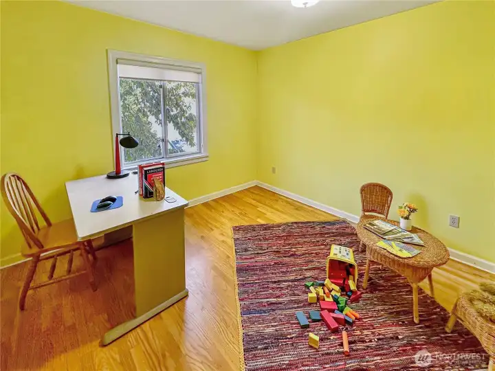 2nd bedroom with oak floors and bright and sunny wall color.