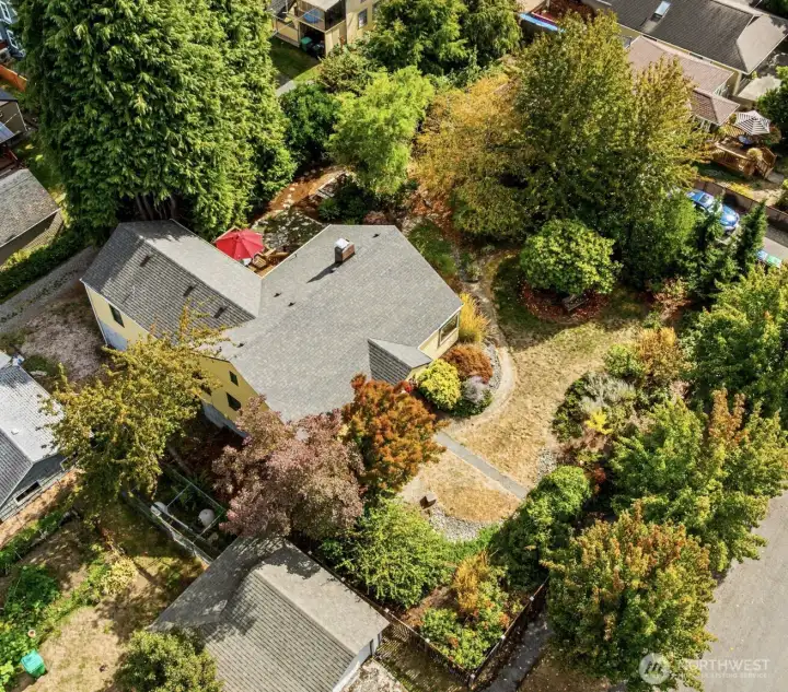 Aerial view showing the roof line, alley access for the 2 car garage and fenced grounds.