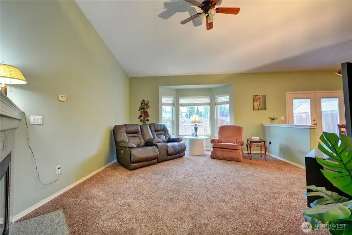 The living room has vaulted ceilings, bay window, cozy gas fireplace and is open to the dining room.