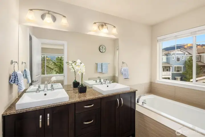 Large primary bathroom with dual vanities, soaking tub and separate walk-in shower enclosure