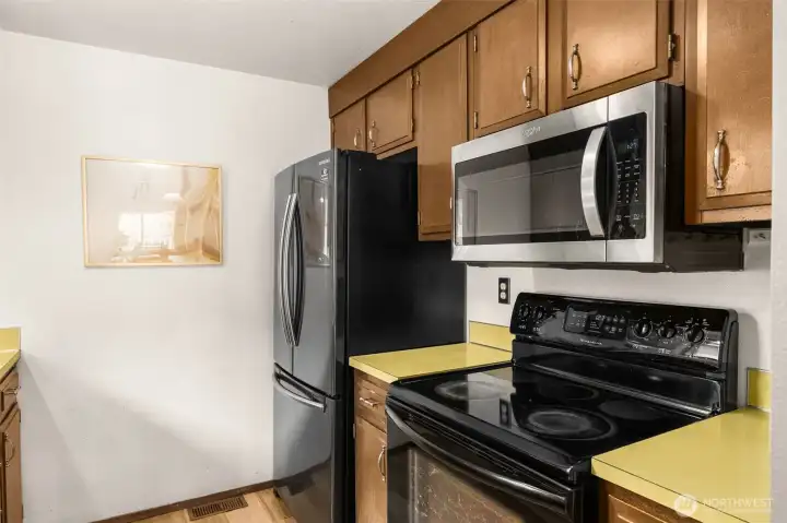Electric range, whirlpool microwave and new Samsung refrigerator.