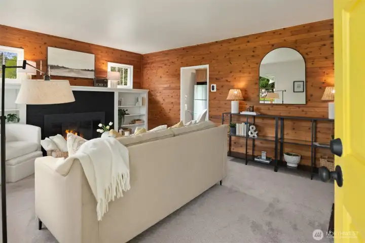 Rich wood walls, abundant natural light, built-in shelving, and a wood-burning fireplace give the living room warmth, personality, and a true sense of home.