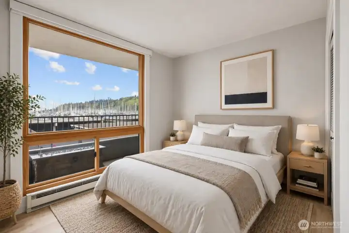 Guest bedroom features a large window overlooking the balcony and Puget Sound beyond. Enjoy a front-row view of sailboats drifting across the water.  [This photo is virtually staged.]