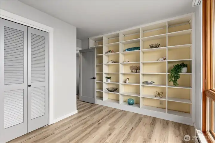 Versatile and light-filled guest bedroom with a wall of custom built-in shelving.
