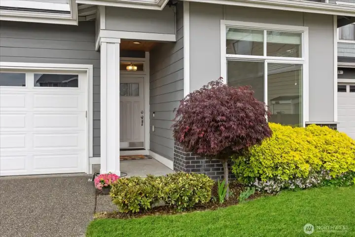 Covered entry with beautiful landscaping