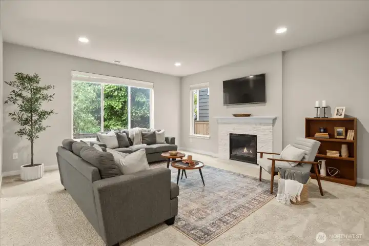 Cozy living space with gas fire and large windows.