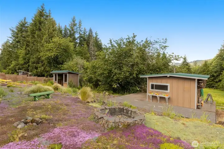 Huge back yard features mature landscaping and fire pit.