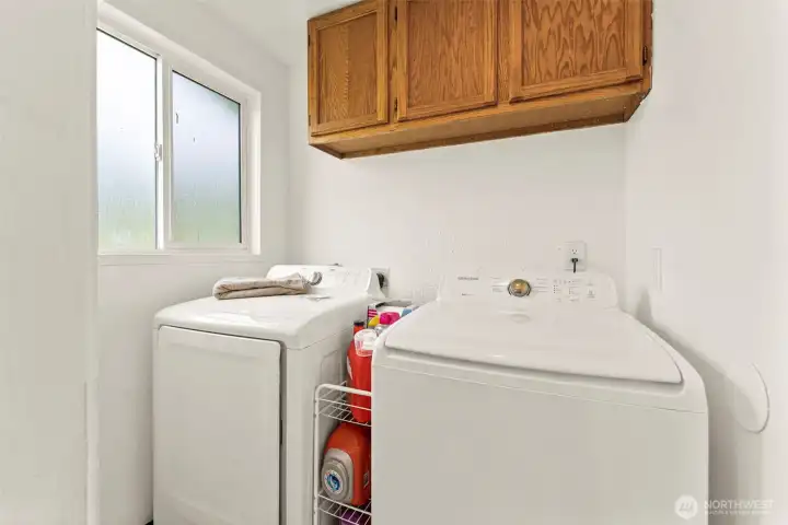 Laundry room with stoage above.