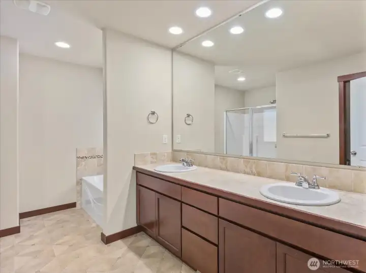 Primary en-suite bath boasts generous space, glowing natural light, and a complete 5-piece layout.