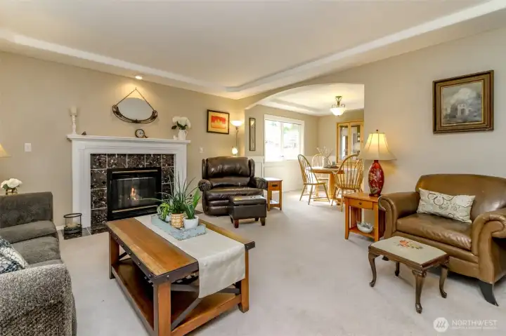 The living room adjoins the formal dining room. The rooms are highlighted with arched entries and trayed ceilings offering a sense of elegance