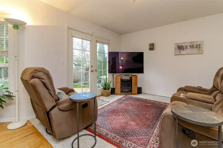The cozy family room offers French doors leading to the expansive deck