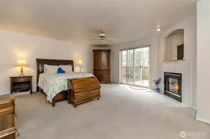 Luxurious primary suite that redefines retreat, featuring generous space and serene ambiance. A private five-piece bath offers bath-time bliss and everyday convenience, while a gas fireplace adds a touch of elegance and warmth to the room. A good sized walk-in closet provides storage and organization, and a sliding glass door leads to a private outdoor space, blending indoor comfort with a seamless connection to the outdoors. This suite is the ultimate haven for relaxation