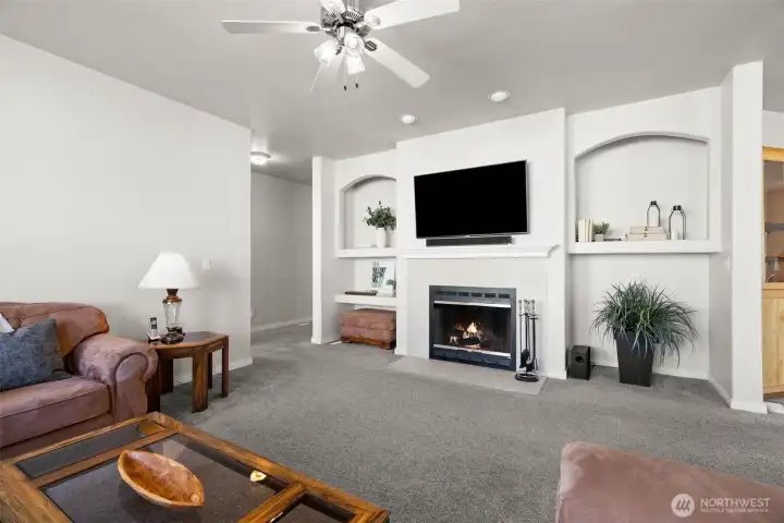 Living room is spacious and comfortable with ceiling fan, wood burning fireplace, built in's.