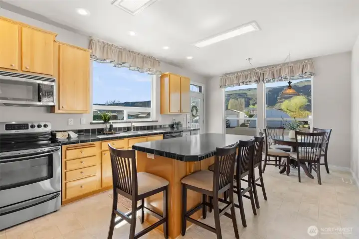 The kitchen is the gather place for this property.  Extra-large island, dining space, lots of cabinet for storage + walk in pantry.  Views of the mountains from every window.