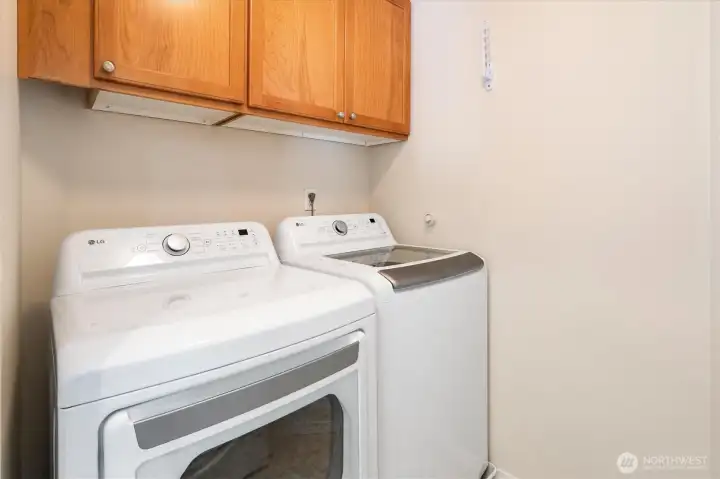 Utility room with lots of cabinets, & almost new washer/dryer.
