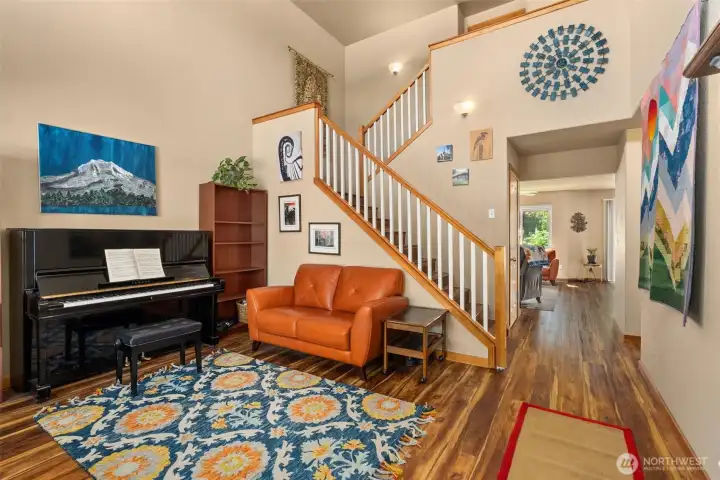 Entry opens to formal living space with soaring ceilings and abundant natural light