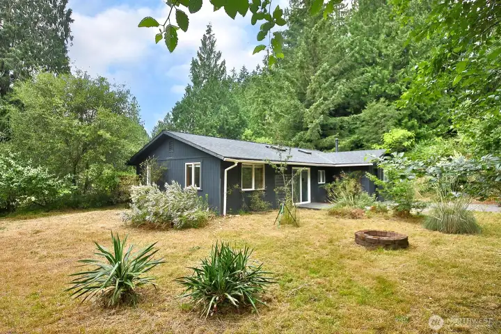 There is a fire pit and retaining wall to define the back area. There is also an elevated view platform to look over the house and entire yard! Hike up the little trail to access the platform. There is a fire pit and retaining wall to define the back area. There is also an elevated view platform to look over the house and entire yard! Hike up the little trail to access the platform.