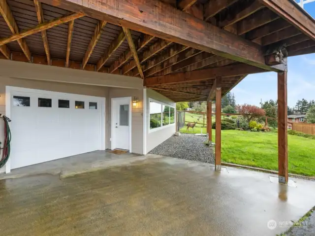 View towards garage & family room exterior entrance from driveway. Deck serves as carport, plenty of parking in driveway, garage etc here!