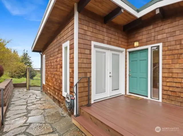 French doors from primary suite open to Trex deck that spans entirety of north and west sides of home.