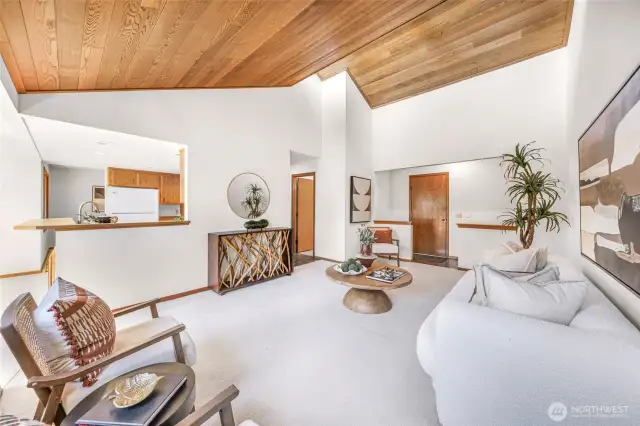Another view of the living room emphasizes its height and openness, with a modern aesthetic and warm wood tones. An inviting blend of comfort and style defines this central gathering space.