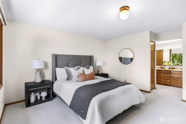 This angle of the primary suite emphasizes room size and connection to the ensuite bathroom. Neutral finishes and natural light enhance the relaxing ambiance.