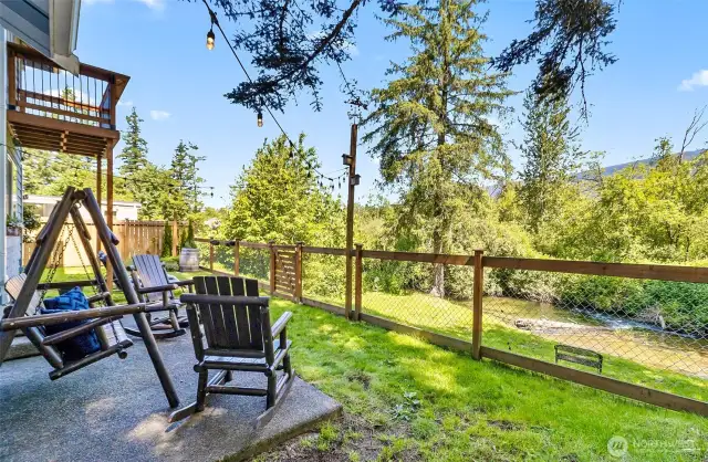 Back yard patio view to creek. Gate to access lower level.