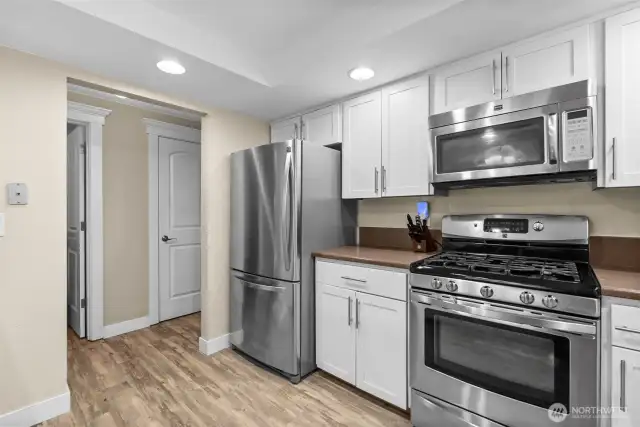 From corner of kitchen looking towards pantry, main level half bath, and garage door entrance
