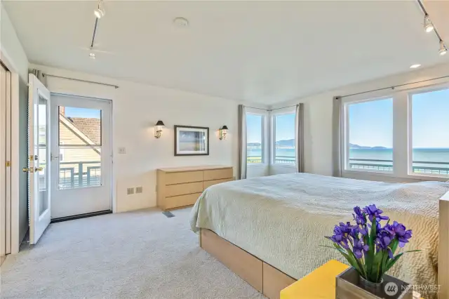 The spacious primary bedroom has stunning views and access to the full wrap-around deck.