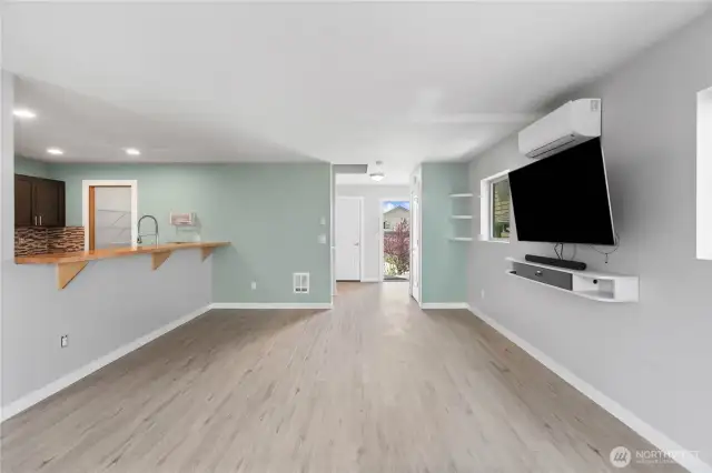 The living room opens to the kitchen barstool seating area.