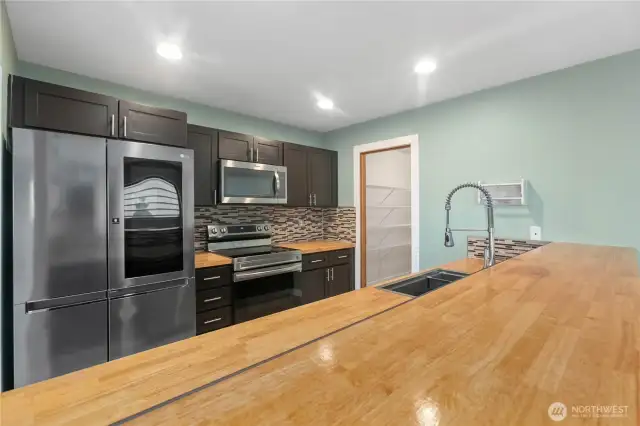 Butcher block countertops and stainless steel appliances.