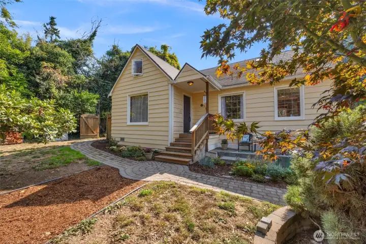 Step into timeless charm with this 1932 Tudor home featuring original coved ceilings and oak hardwood floors.