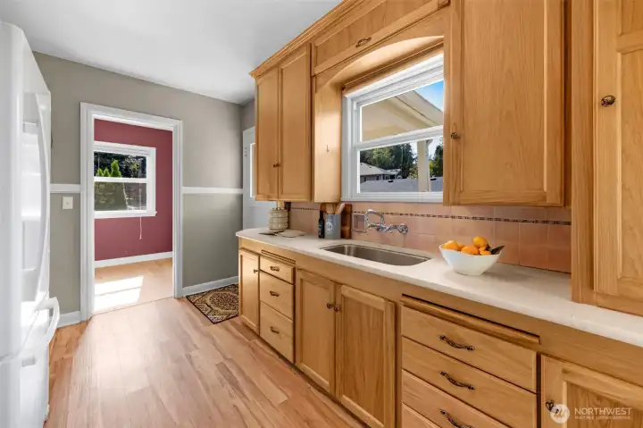The simple kitchen style has ample cabinets and flows into the dining area.