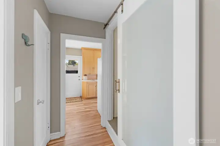 The main floor hallway between the primary bedroom, bath and kitchen area is light & bright and flows easily in this circular floor plan.