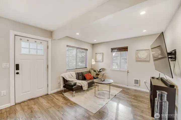 Sun filled living room and gleaming floors in the open concept living area.