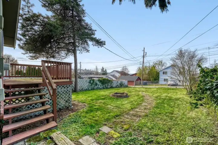 Large deck overlooks the fire pit and fenced yard.