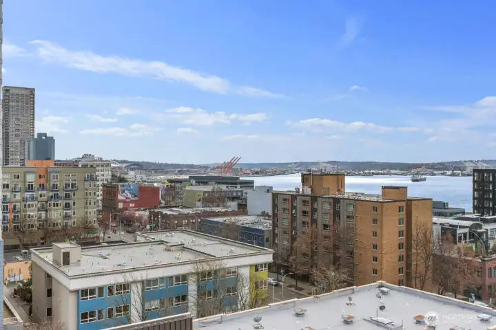 Seattle skyline and Puget Sound view condo overlooking the working waterfront, harbor activity, and surrounding cityscape.