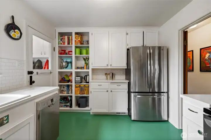 Remodeled kitchen with built in pantry shelves, SS appliances and Marmoleum flooring