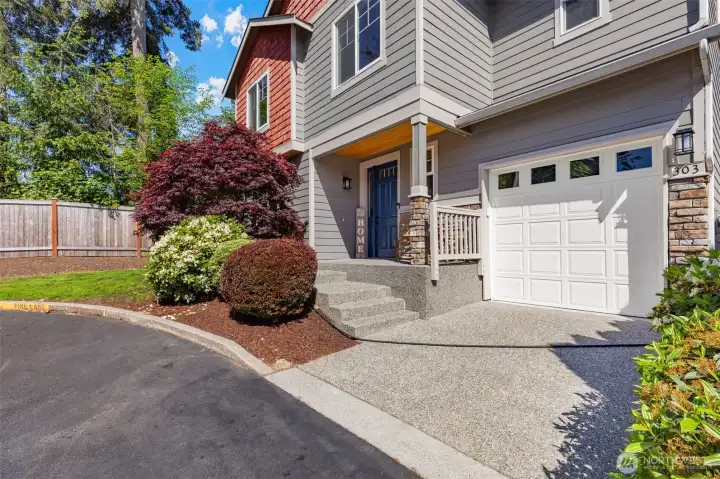 Front yard professionally maintained features mature landscaping