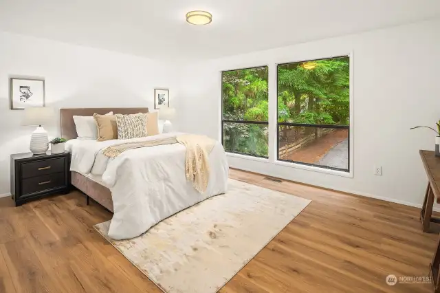 The primary bedroom has large windows to the front of the house, a wall of closets and an ensuite bathroom.