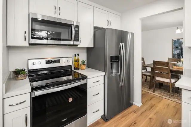 A great view of the new stove, microwave that vents out through the roof and the new refridgerator.