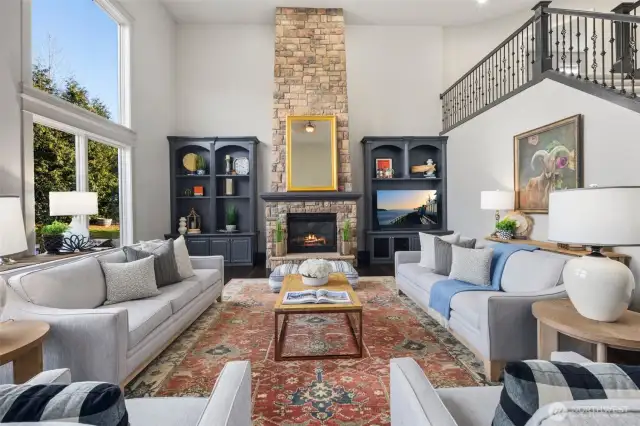 WOW! The Impressive Family Room With 2-Story Ceiling Is Designed For Both Grandeur And Comfort. Built-In Custom Shelving Surrounds The Stone Fireplace.
