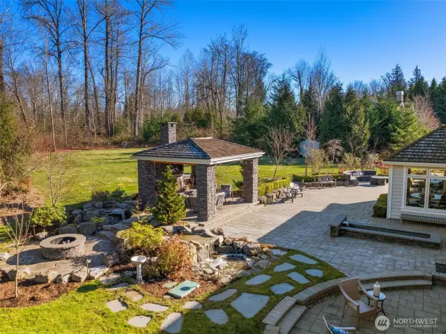 The Expansive Stone Patio Is Designed For Both Style And Comfort, Featuring Multiple Seating Areas Ideal For Gatherings Or Quiet Moments. Two Gas Fireplace Seating Areas....
