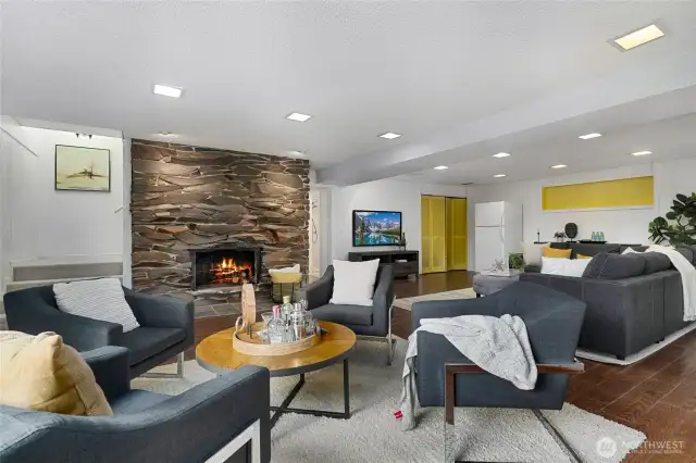 Lower level recreation room and additional seating area, with stone fireplace and hardwood floors