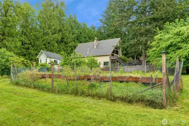 Multiple fruit trees, raised planter beds and multiple rhododendrons!